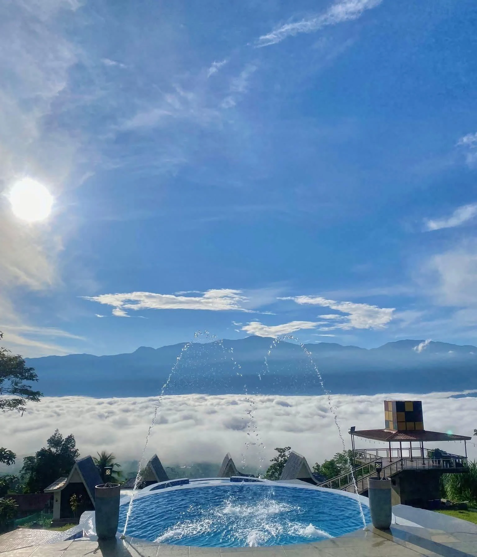 Morning sun over a sea of clouds, mountain ridges and a swimming pool at Odyson’s Mountain Resort